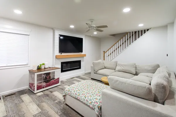 a living room with furniture a flat screen tv and a fireplace