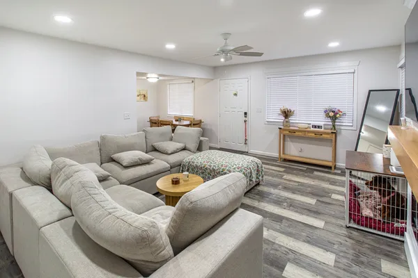 a living room with furniture and a wooden floor
