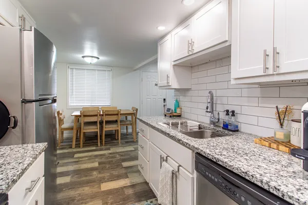 a kitchen with stainless steel appliances granite countertop a sink stove and refrigerator