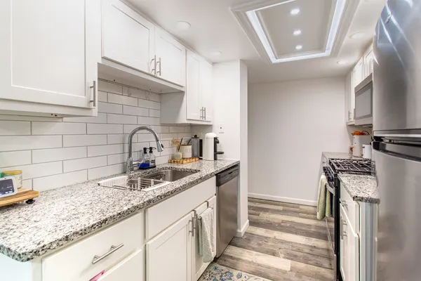 a kitchen with stainless steel appliances granite countertop a sink stove and refrigerator