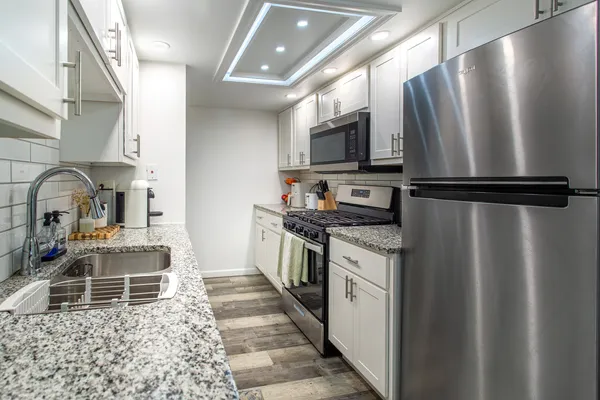 a kitchen with stainless steel appliances a refrigerator sink and microwave
