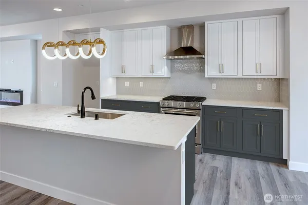 a kitchen with stainless steel appliances a sink dishwasher and cabinets with wooden floor