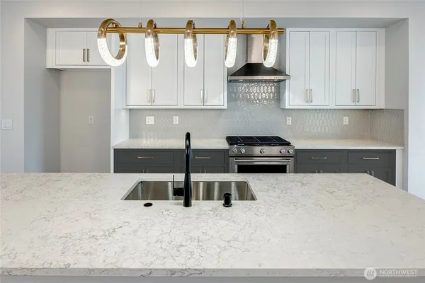 a kitchen with stainless steel appliances granite countertop a stove a sink and a refrigerator