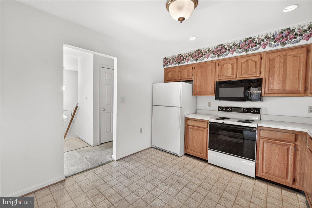 4715 Green Valley Road Monrovia, MD 21770 - Photo 13 of 36 a kitchen with granite countertop a refrigerator and a stove top oven