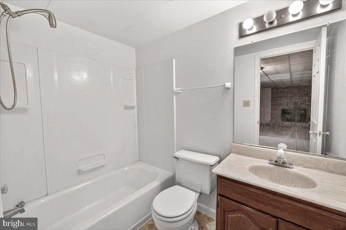 4715 Green Valley Road Monrovia, MD 21770 - Photo 25 of 36 a bathroom with a granite countertop sink toilet a mirror and shower