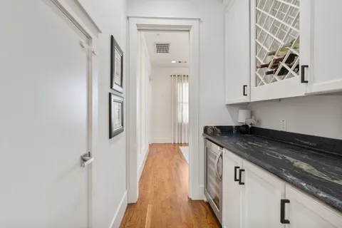 a kitchen with stainless steel appliances kitchen island granite countertop a stove a sink and a wooden floors