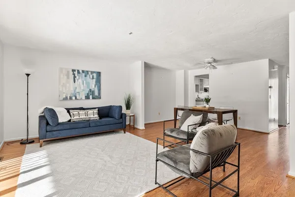 a living room with furniture and a wooden floor