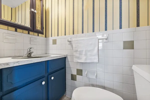 a bathroom with a toilet a sink and mirror