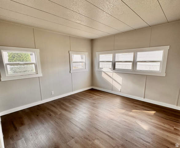 158 Cushing Way Layton, UT 84041 - Photo 12 of 14 Spacious interior featuring wood-finish flooring, light-toned walls, multiple windows, and white trim