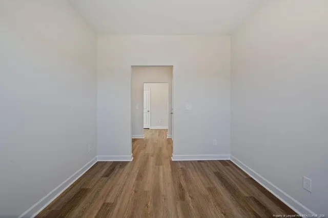 a view of a room with wooden floor and a window
