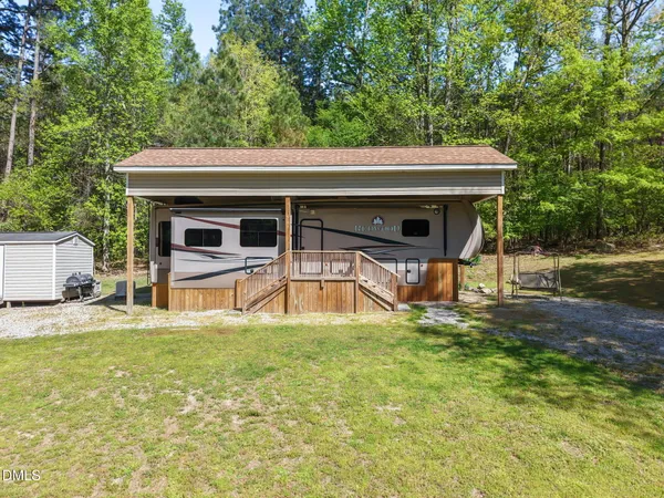 a view of a house with pool and chairs