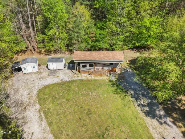 an aerial view of a house with swimming pool and large trees