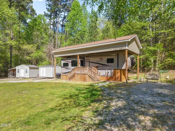 a view of a house with backyard and a tree
