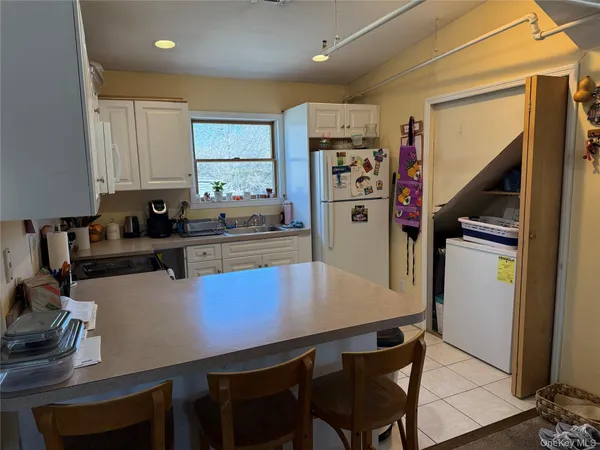 a kitchen with a table chairs refrigerator and cabinets