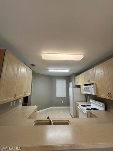 14732 Sutherland Avenue, Unit 332 Naples, FL 34119 - Photo 11 of 33 Kitchen with white appliances, light countertops, a peninsula, and light wood finish cabinets
