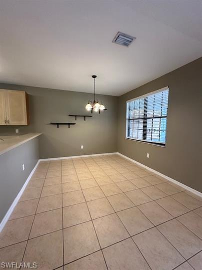 14732 Sutherland Avenue, Unit 332 Naples, FL 34119 - Photo 12 of 33 Unfurnished dining area with hanging lights and light tile patterned floors