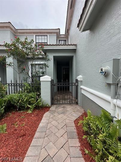 14732 Sutherland Avenue, Unit 332 Naples, FL 34119 - Photo 2 of 33 Property entrance featuring a gate and stucco siding