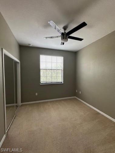 14732 Sutherland Avenue, Unit 332 Naples, FL 34119 - Photo 25 of 33 Unfurnished bedroom featuring light colored carpet, a closet, and a ceiling fan