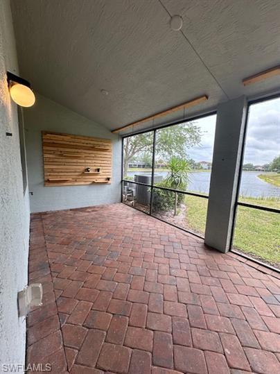 14732 Sutherland Avenue, Unit 332 Naples, FL 34119 - Photo 28 of 33 Unfurnished sunroom featuring vaulted ceiling and a water view