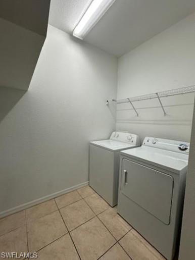 14732 Sutherland Avenue, Unit 332 Naples, FL 34119 - Photo 29 of 33 Laundry area featuring washing machine and clothes dryer and light tile patterned flooring