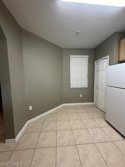14732 Sutherland Avenue, Unit 332 Naples, FL 34119 - Photo 8 of 33 Unfurnished dining area with arched walkways and light tile patterned flooring