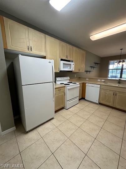 14732 Sutherland Avenue, Unit 332 Naples, FL 34119 - Photo 9 of 33 Kitchen with white appliances, light countertops, light tile patterned flooring, light wood finish cabinets, and suspended lighting