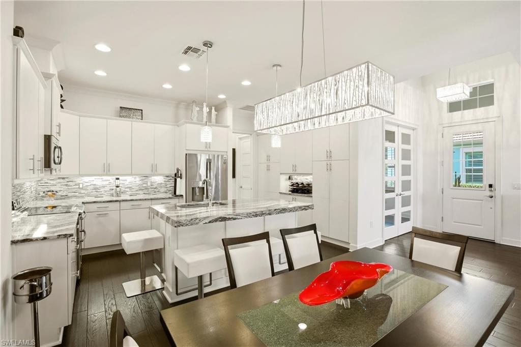 7157 Dominica Drive Naples, FL 34113 - Photo 13 of 39 a kitchen with stainless steel appliances granite countertop a kitchen island hardwood floor and a sink