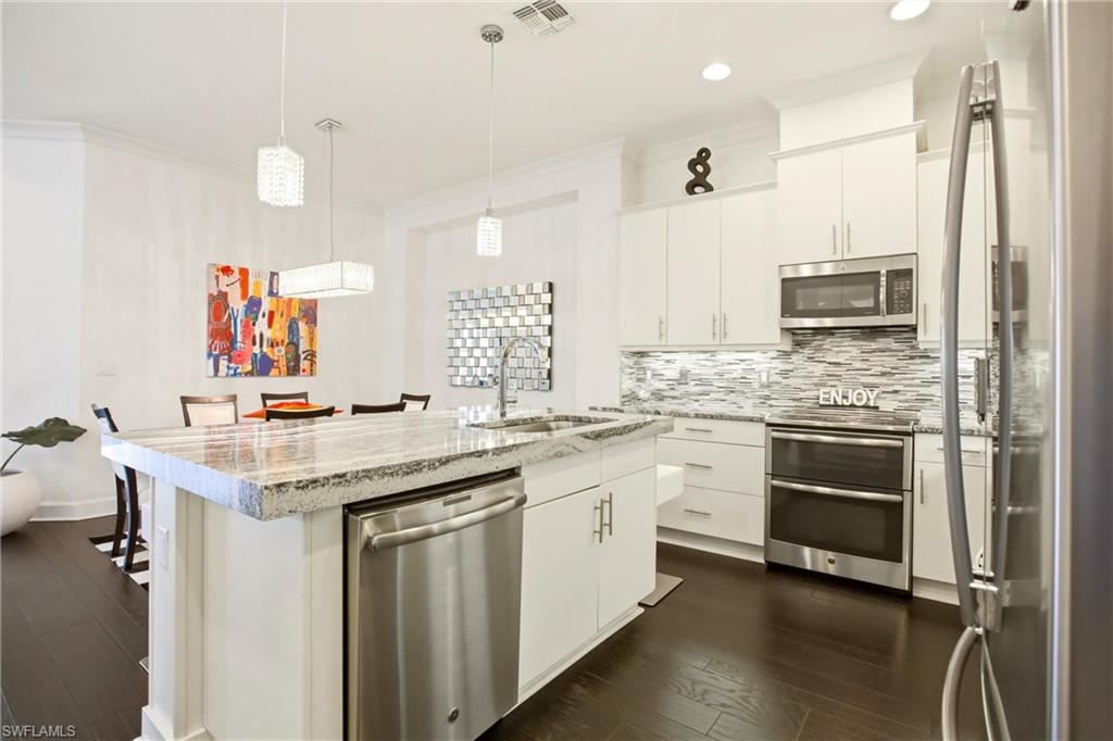 7157 Dominica Drive Naples, FL 34113 - Photo 8 of 39 a kitchen with stainless steel appliances granite countertop a stove and cabinets