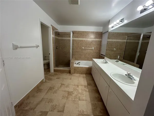a spacious bathroom with a shower a sink and mirror