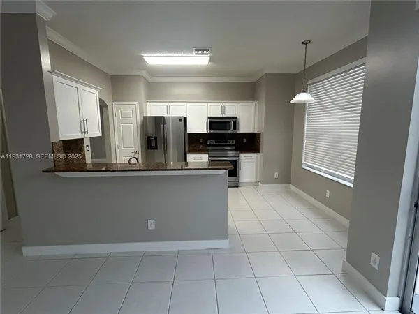 a kitchen with stainless steel appliances a refrigerator and microwave