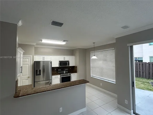 a view of a kitchen with furniture and a refrigerator