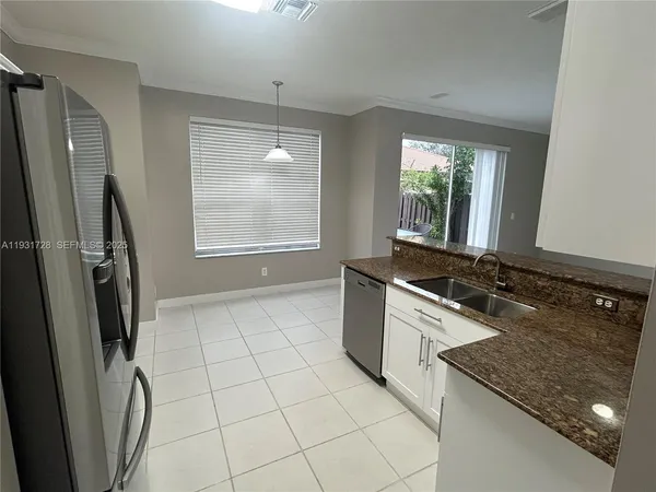 a metallic refrigerator freezer sitting in a kitchen