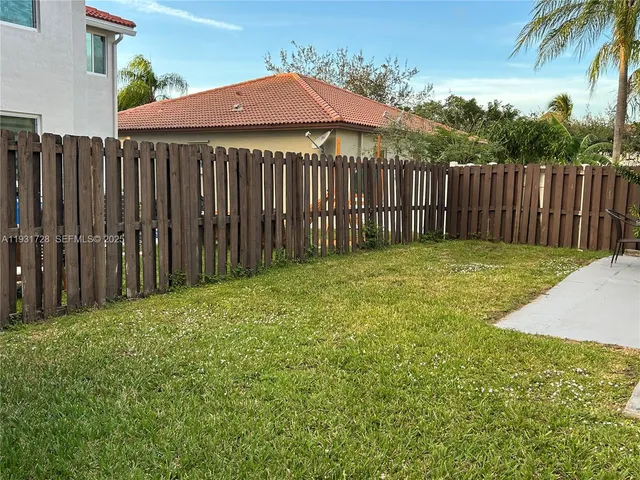 a view of a backyard with wooden fence