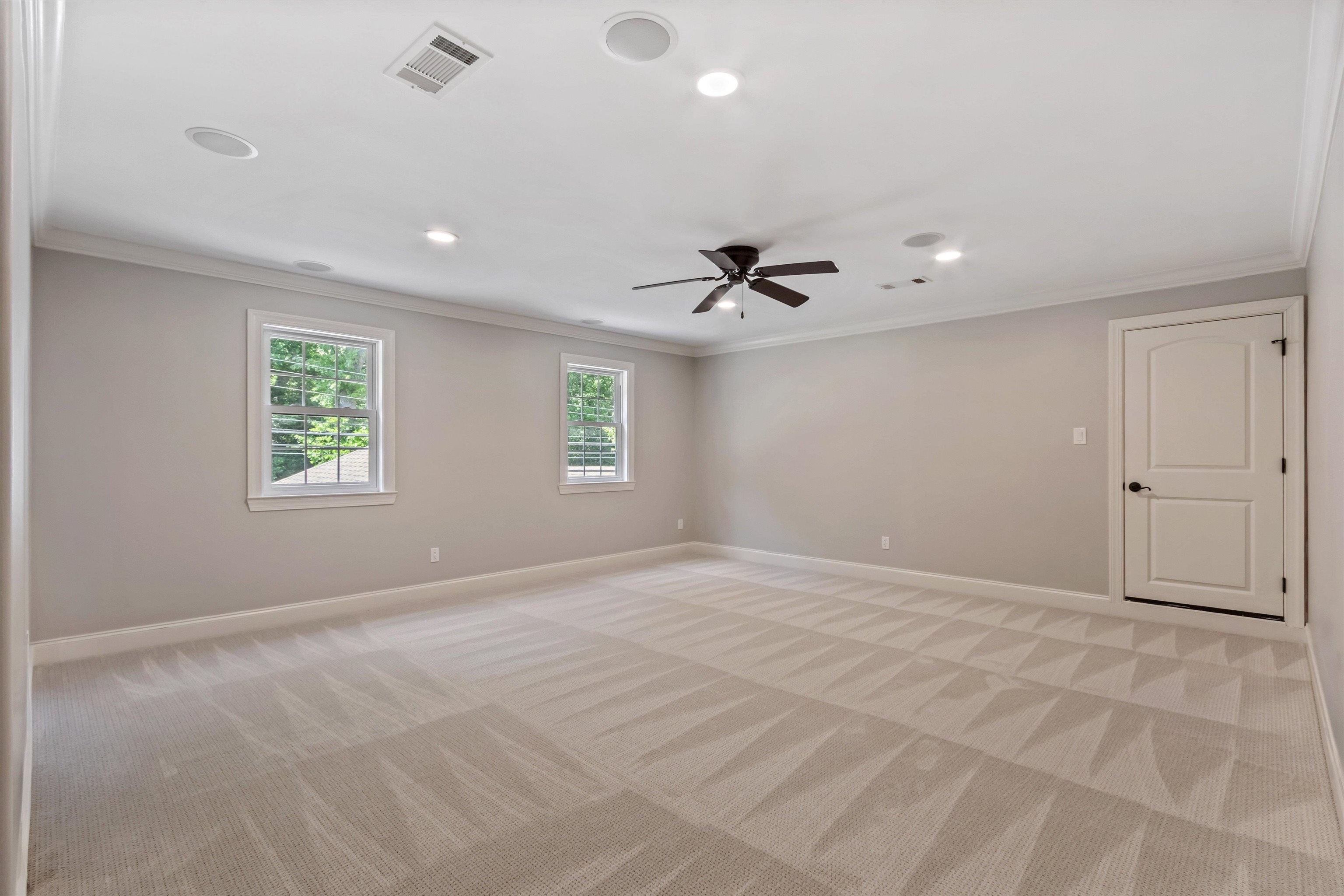 5302 South Angela Road Memphis, TN 38120 - Photo 31 of 40 Spacious room featuring patterned carpeting, two windows, a ceiling fan, recessed lighting, and crown molding