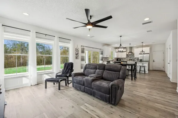 a dining room with furniture a chandelier and wooden floor