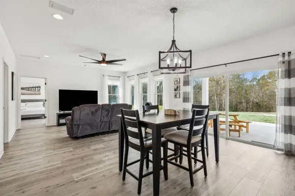 a kitchen with stainless steel appliances kitchen island granite countertop a stove a sink a refrigerator and white cabinets with wooden floor