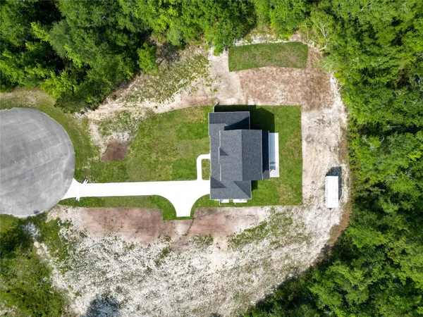 an aerial view of a house with a yard
