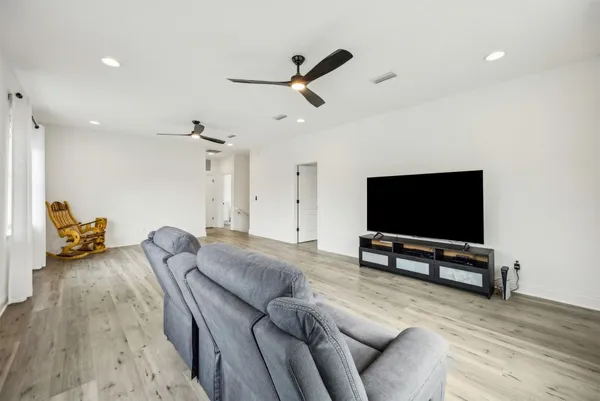 a living room with furniture and a wooden floor