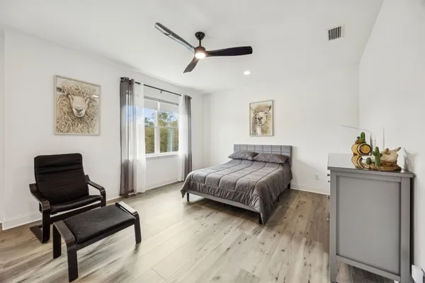 a bedroom with a bed and wooden floor