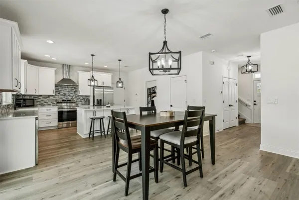 a view of a dining room and livingroom with furniture wooden floor a chandelier