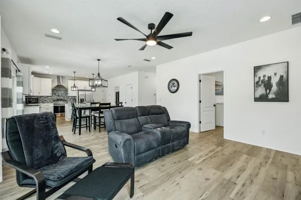 a living room with furniture and kitchen view
