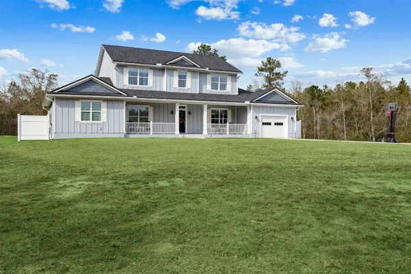 a view of a house with a small yard and wooden fence