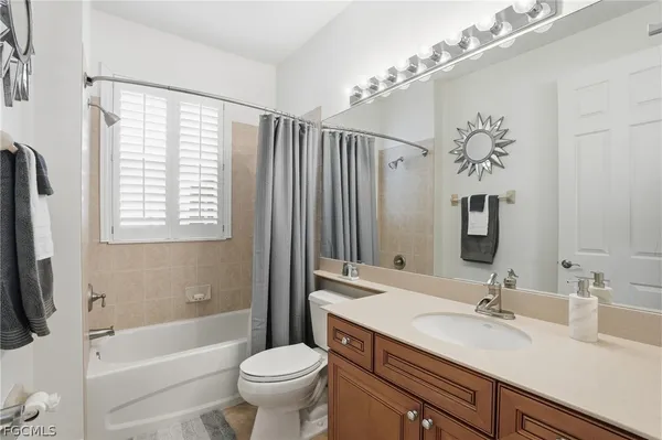 a bathroom with a sink a toilet a mirror a bathtub and shower