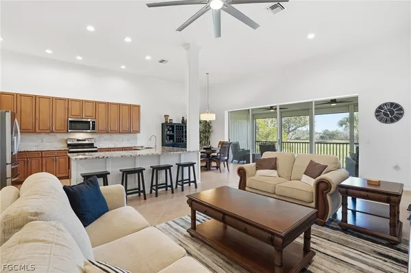 a living room with stainless steel appliances furniture and a kitchen