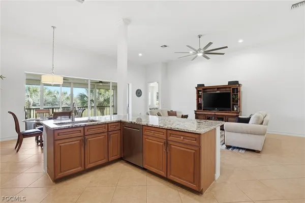 a living room with furniture a flat screen tv and a view of kitchen