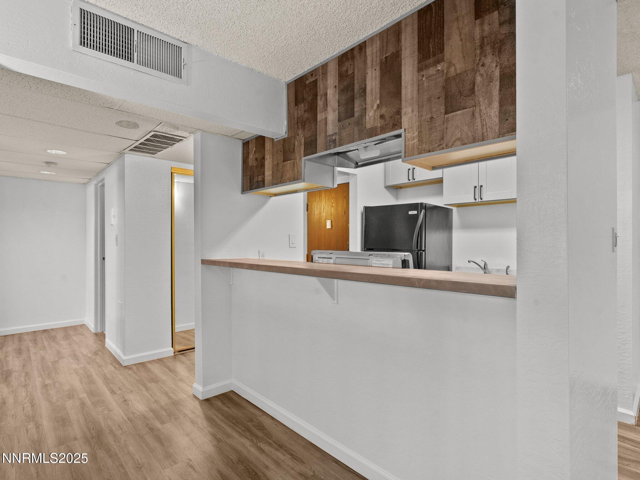 2955 Lakeside Drive, Unit 111 Reno, NV 89509 - Photo 11 of 45 a kitchen with wooden cabinets and a refrigerator