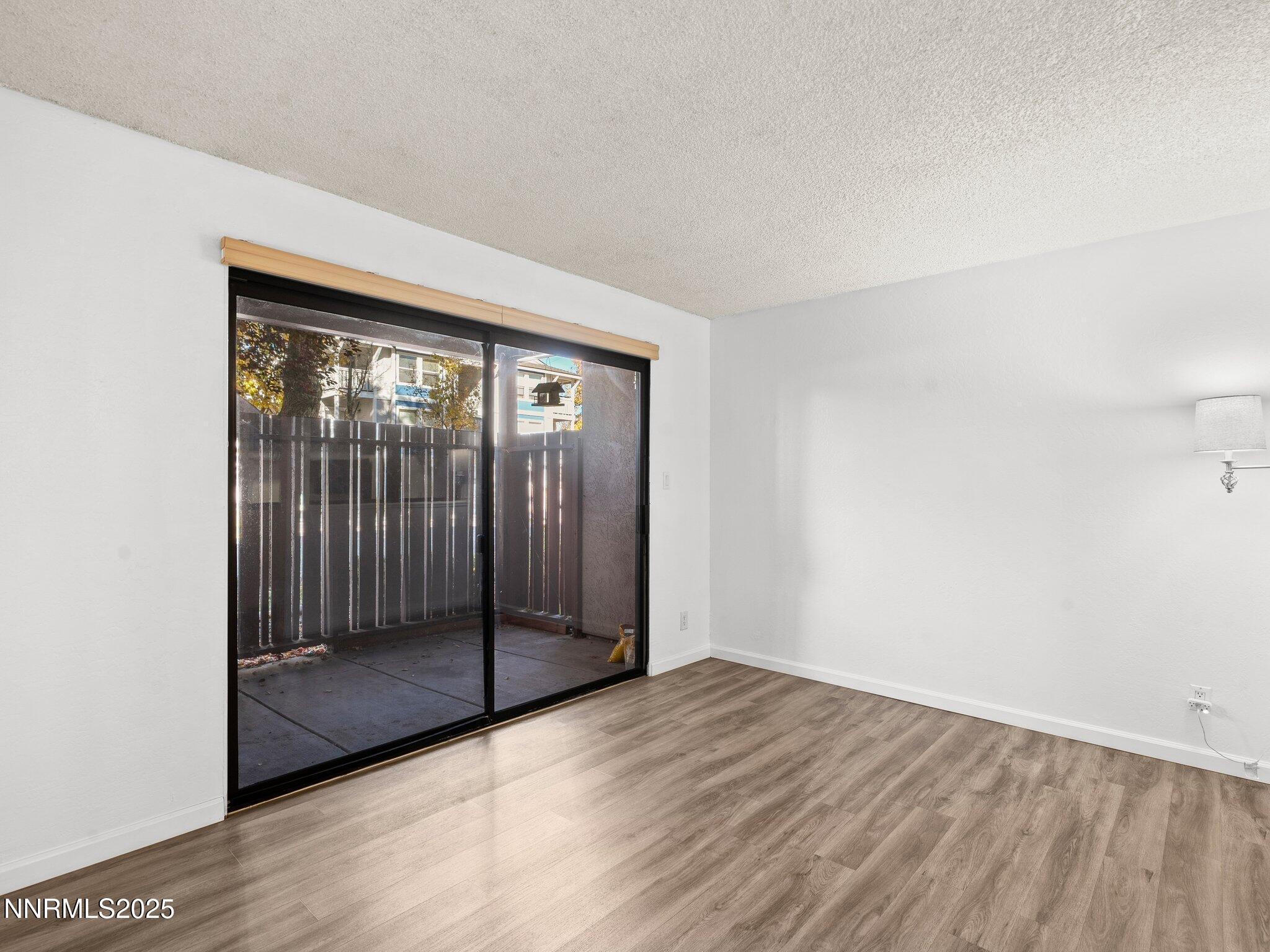 2955 Lakeside Drive, Unit 111 Reno, NV 89509 - Photo 13 of 45 an empty room with wooden floor and windows