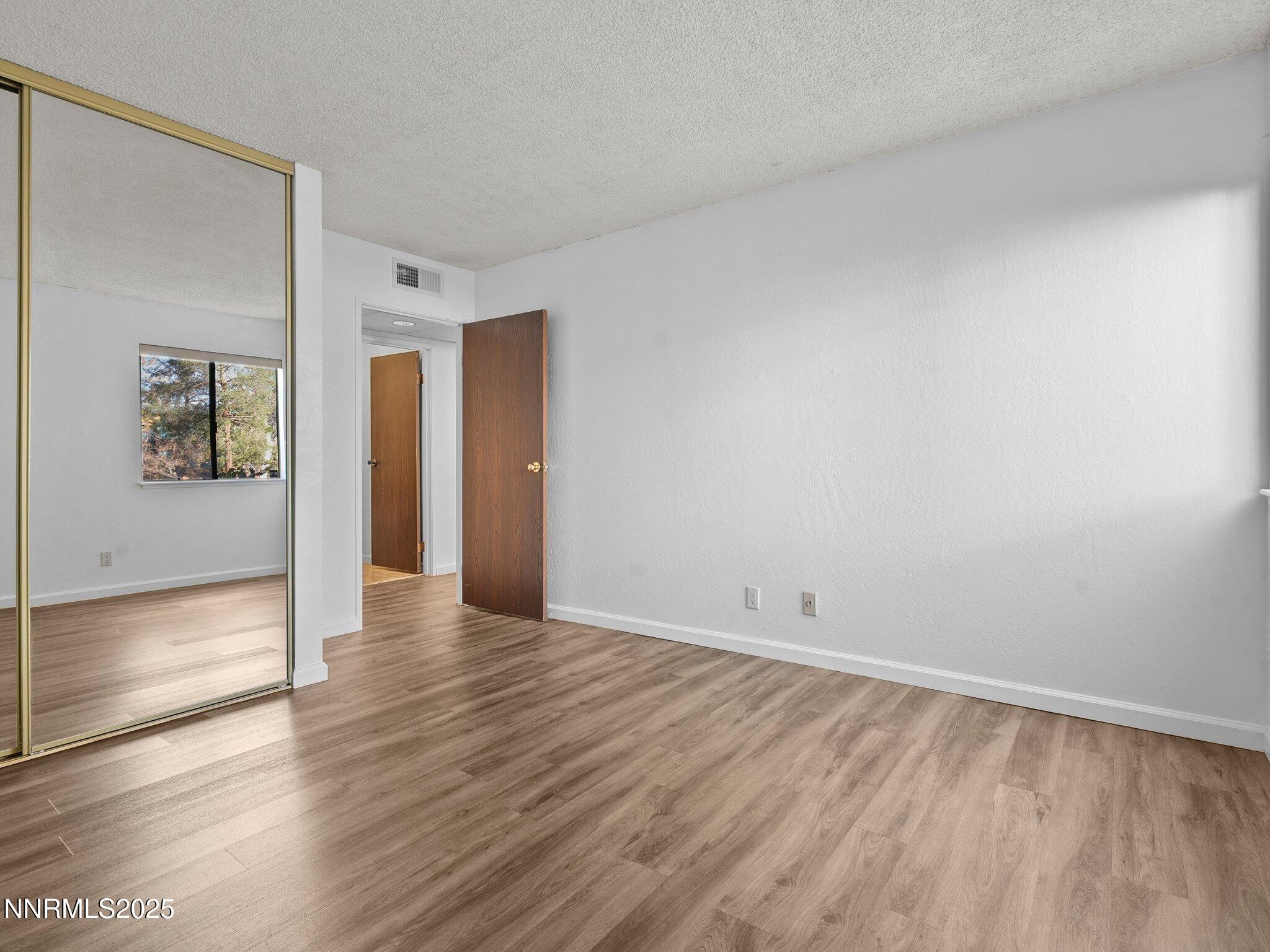 2955 Lakeside Drive, Unit 111 Reno, NV 89509 - Photo 17 of 45 a view of an empty room with wooden floor and a window