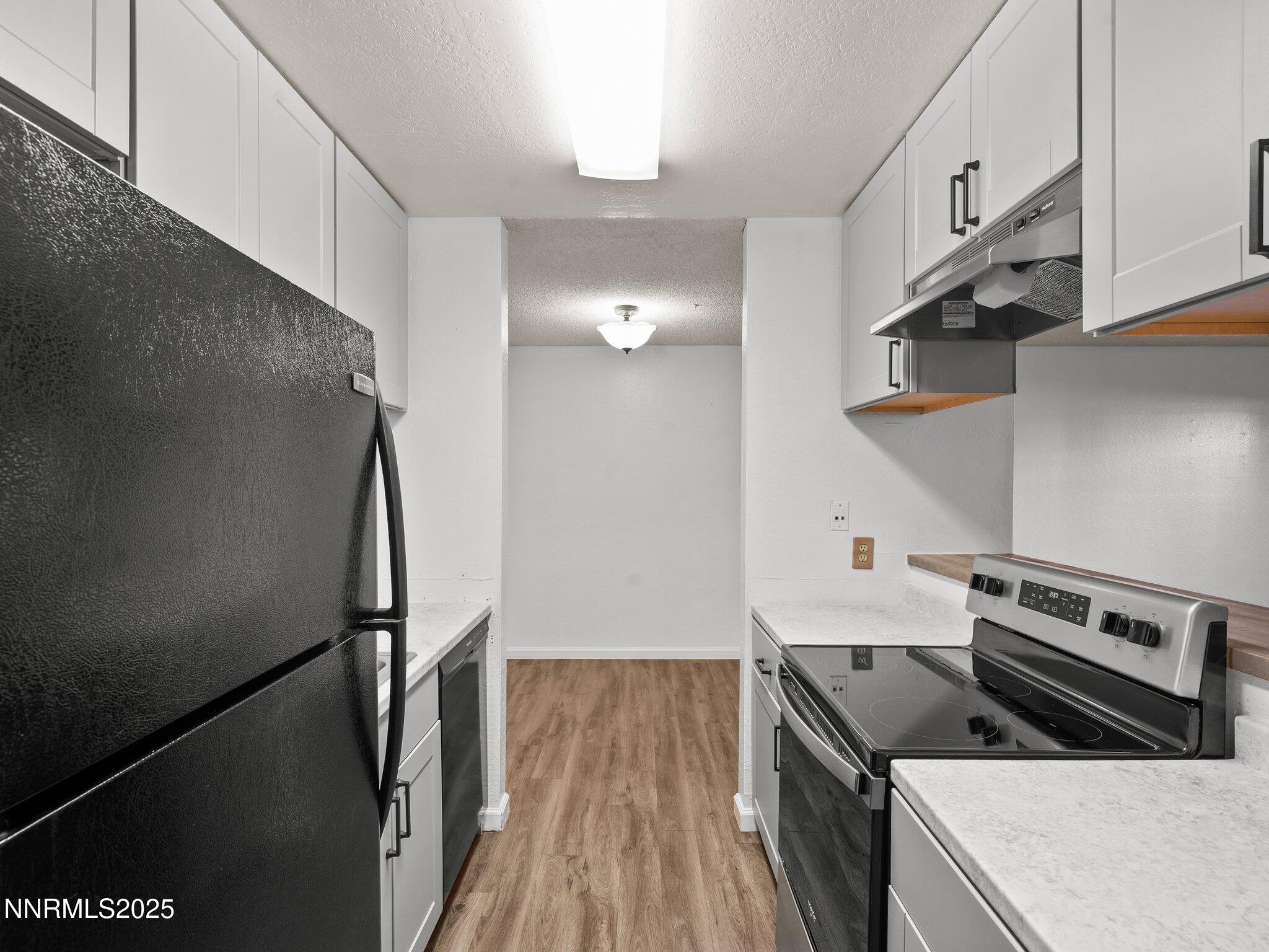 2955 Lakeside Drive, Unit 111 Reno, NV 89509 - Photo 3 of 45 a kitchen with stainless steel appliances granite countertop a refrigerator a stove and a sink with wooden floor