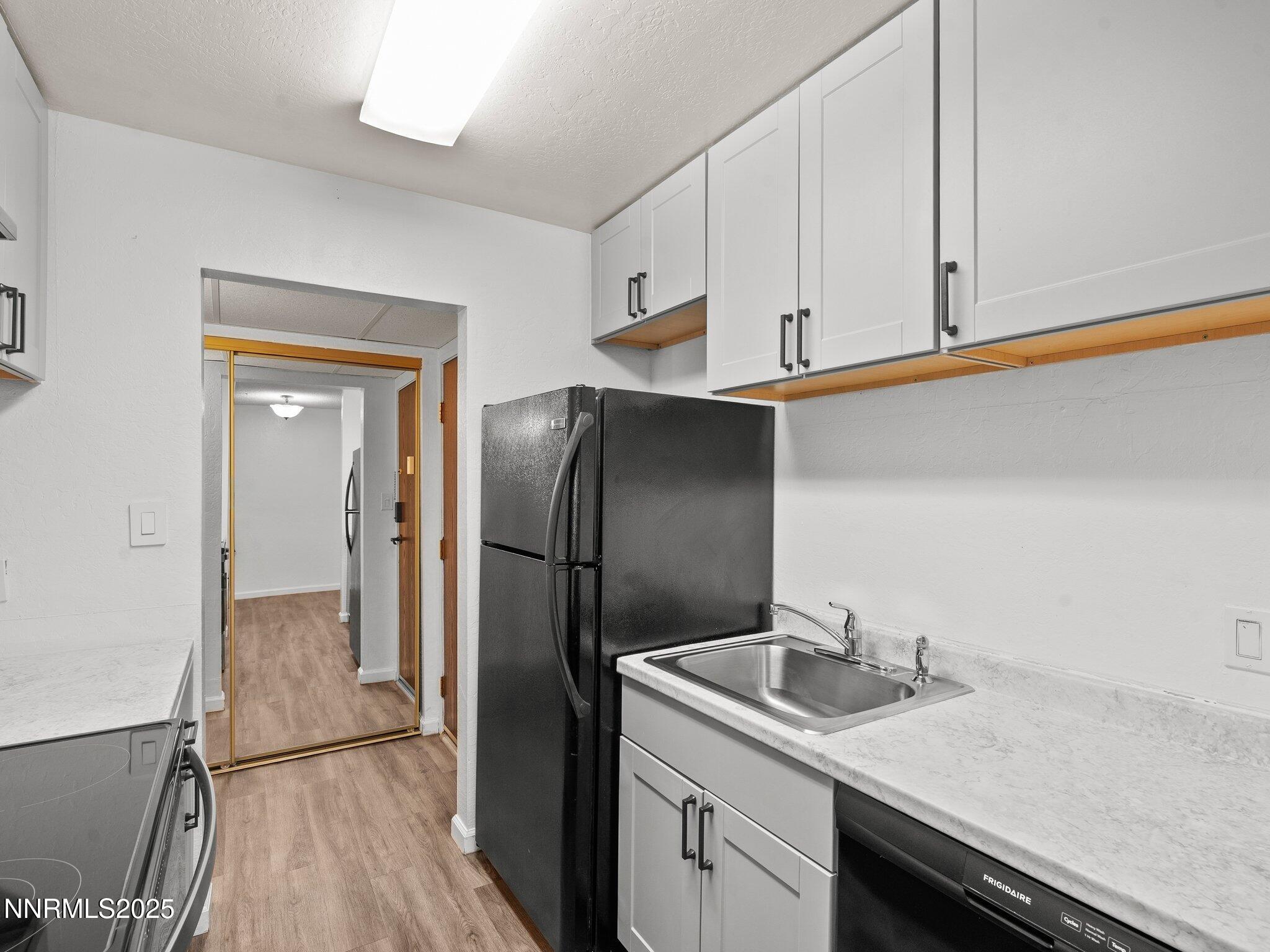 2955 Lakeside Drive, Unit 111 Reno, NV 89509 - Photo 6 of 45 a kitchen with stainless steel appliances granite countertop a sink and a refrigerator